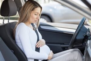Pregnant woman in car experiencing labor pains