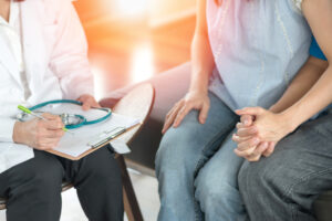 man and woman talking to doctor about infertility options