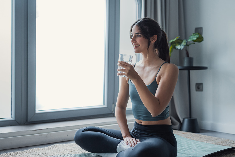 Woman drinking a glass of water at home